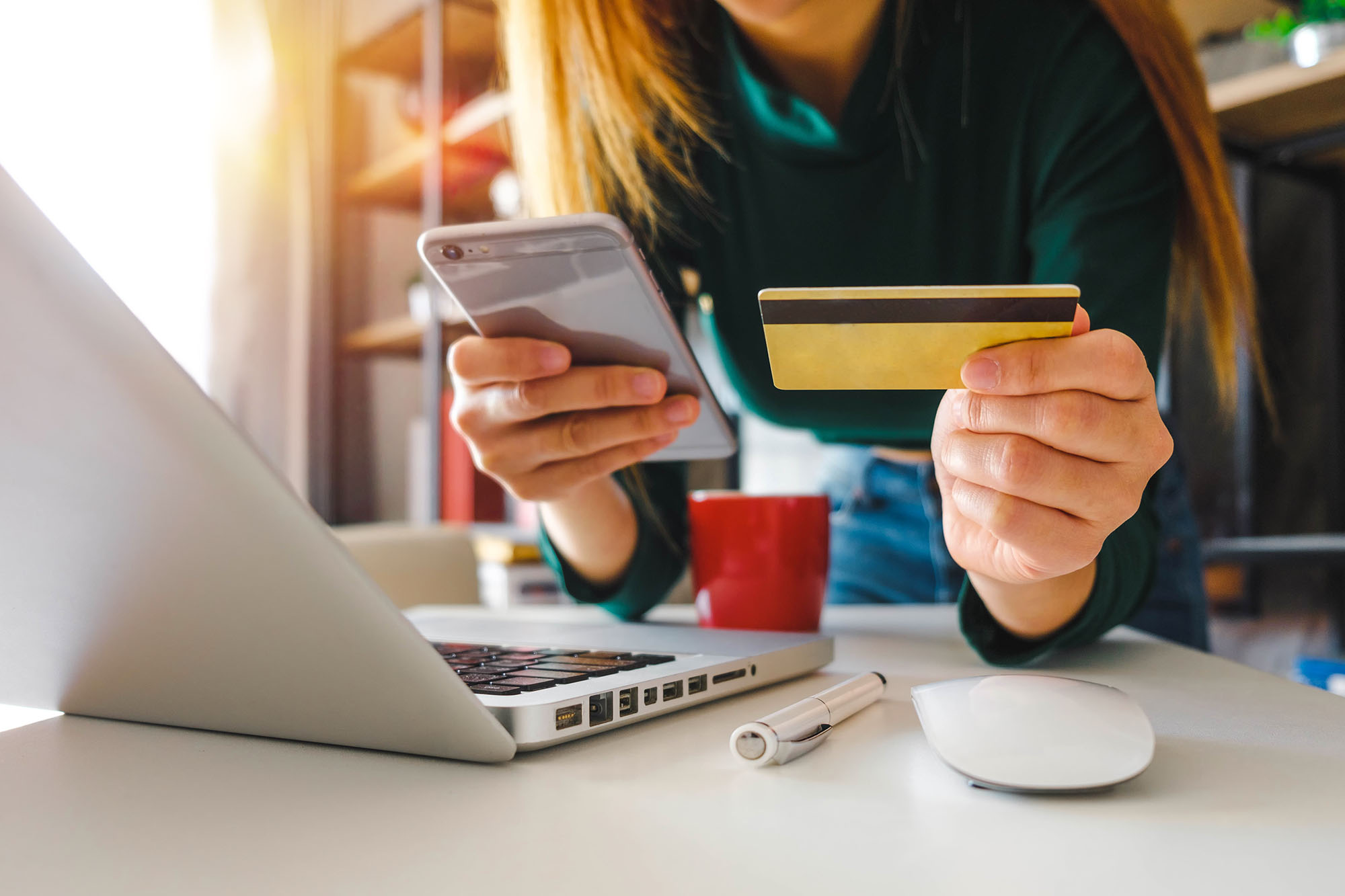 a business woman holding a credit card and a phone