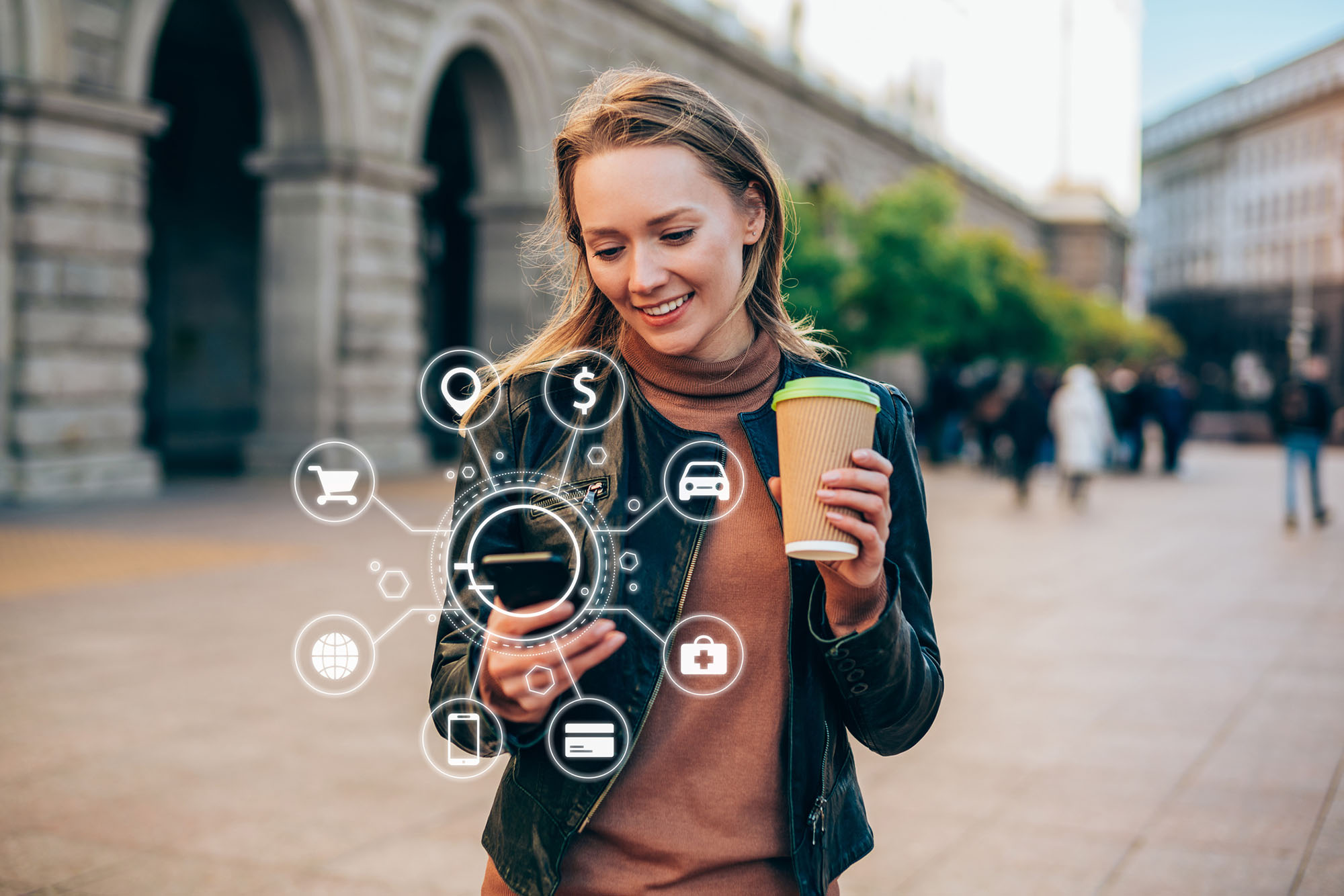 A bank customer holds her coffee with her left hand while performing banking transactions on their mobile phone with her right hand