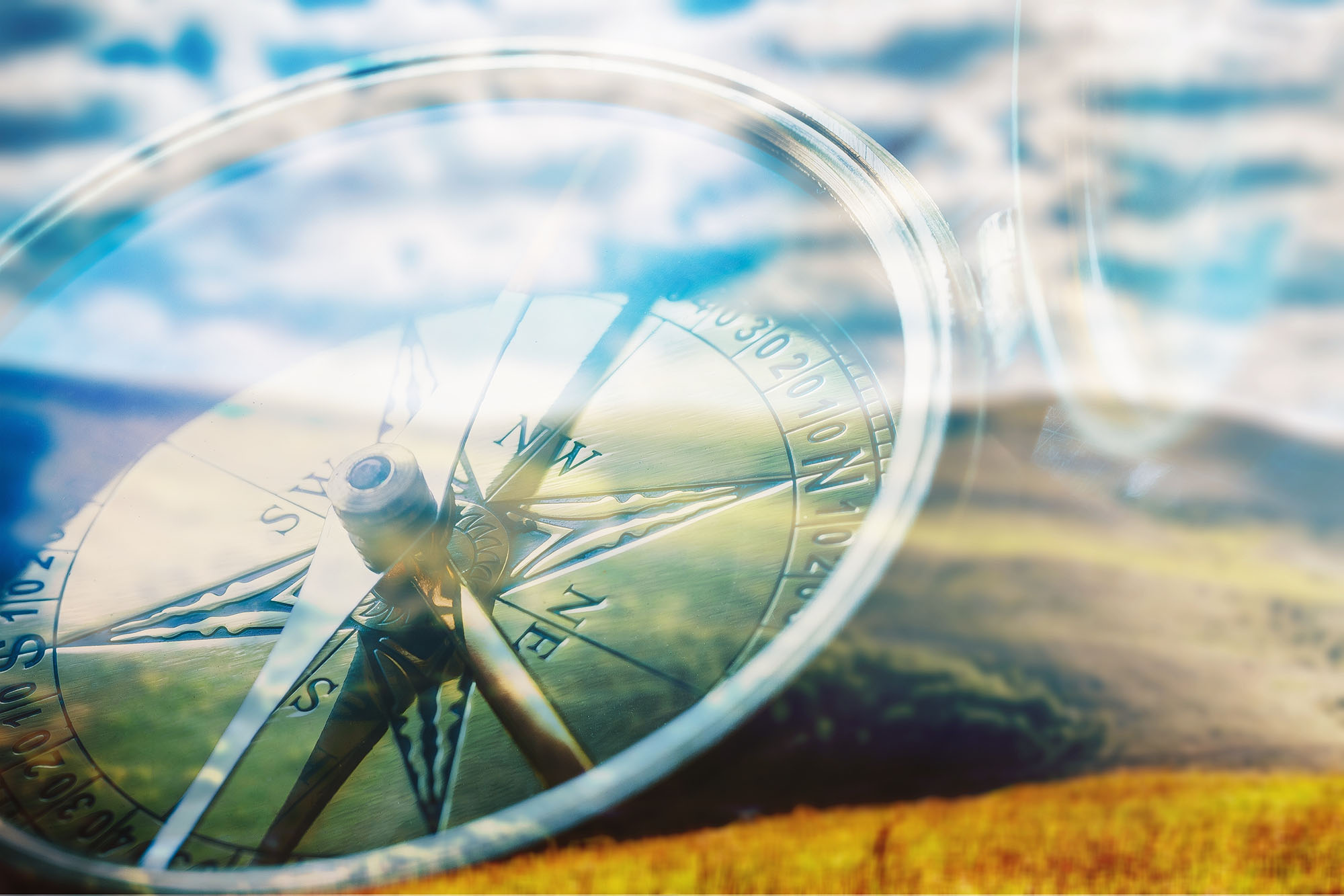 compass with sky reflection on glass surface