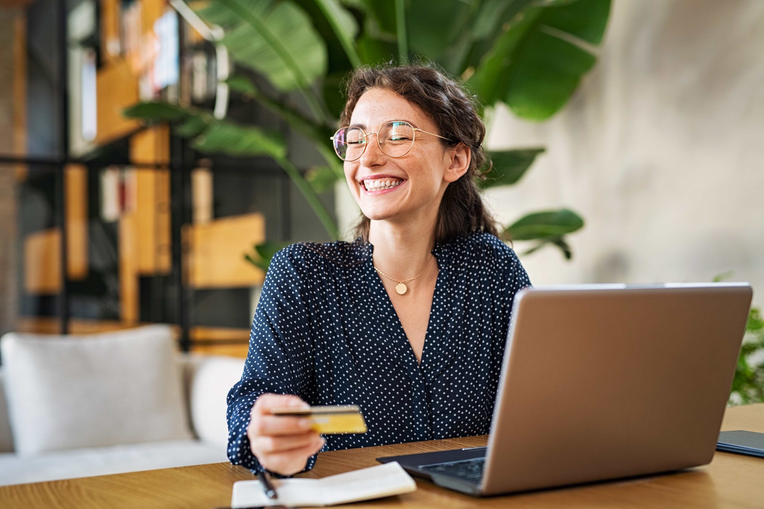 a business woman holding a credit card with a big smile on her face